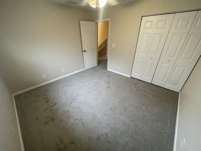 unfurnished bedroom featuring ceiling fan, a closet, and carpet