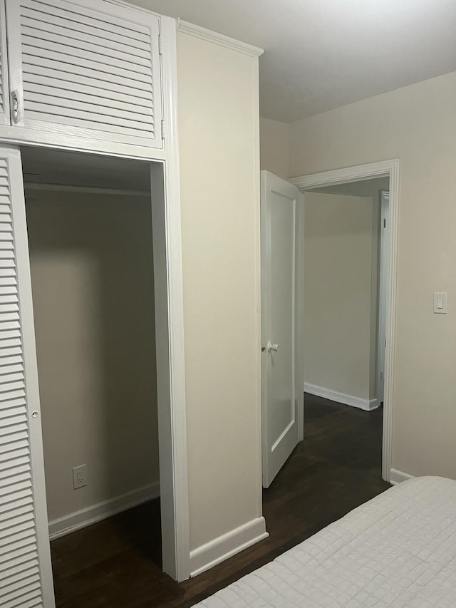 unfurnished bedroom with dark hardwood / wood-style floors and a closet