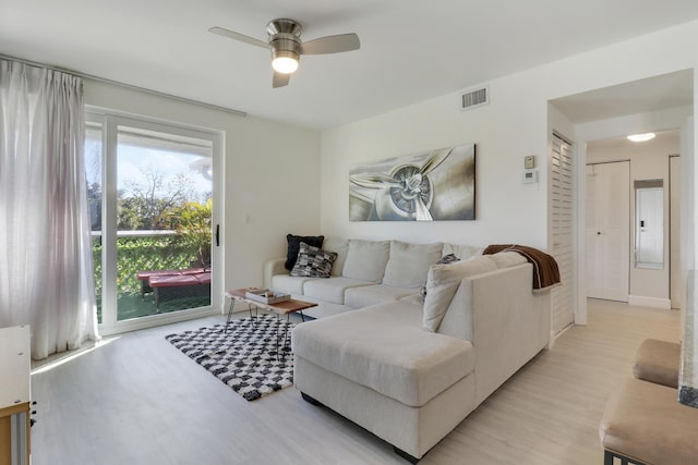 living room featuring light hardwood / wood-style flooring and ceiling fan