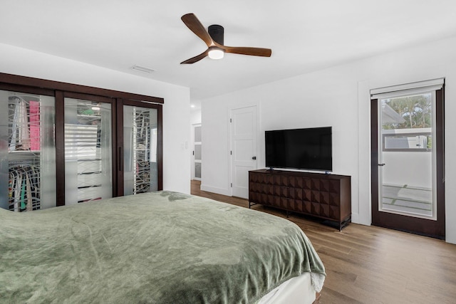 bedroom with hardwood / wood-style floors, ceiling fan, and access to outside