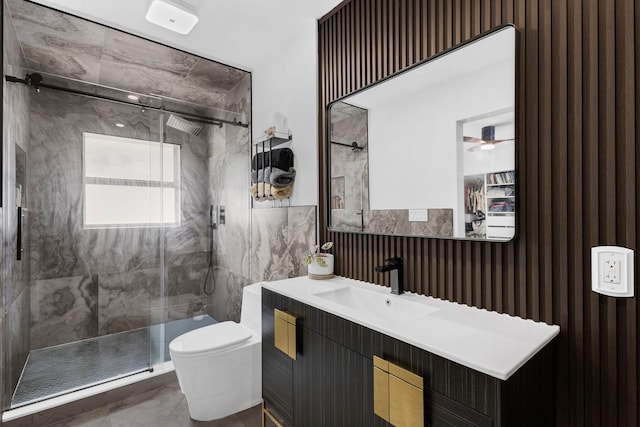 bathroom featuring a shower with door, vanity, and toilet