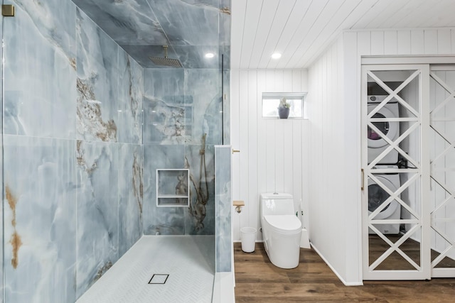 bathroom featuring hardwood / wood-style floors, a tile shower, and toilet