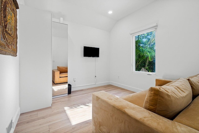 living area with light hardwood / wood-style floors and lofted ceiling