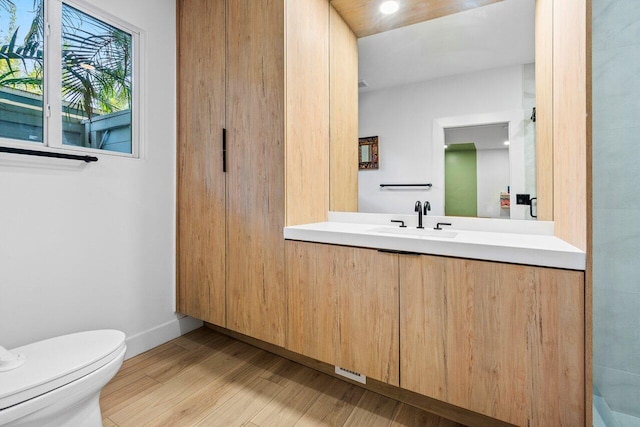 bathroom featuring hardwood / wood-style flooring, vanity, and toilet