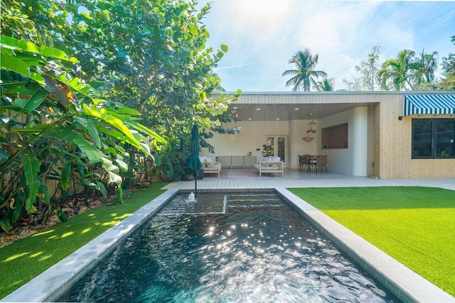 view of swimming pool with an outdoor living space, a patio area, and a lawn