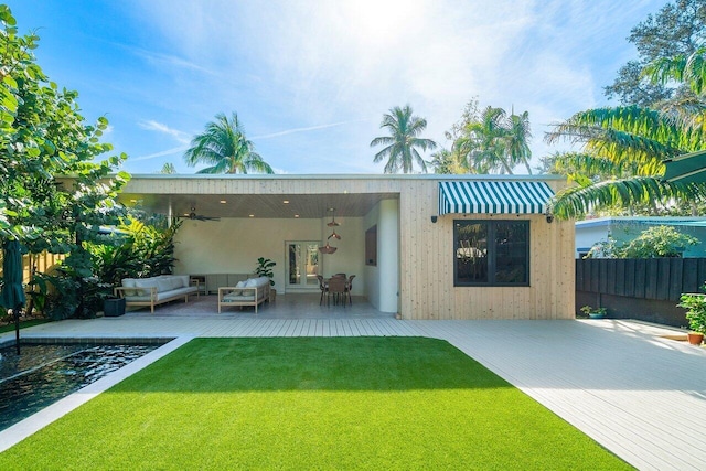 back of house featuring an outdoor hangout area, a patio, and a lawn