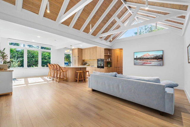 living room featuring beam ceiling, light wood-type flooring, high vaulted ceiling, and wooden ceiling