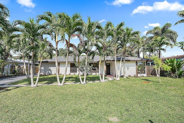 view of front of house with a front yard and fence