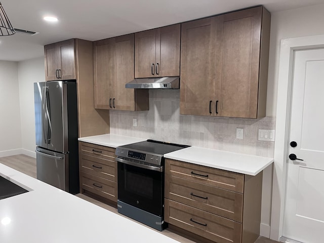 kitchen with dark brown cabinetry, appliances with stainless steel finishes, and tasteful backsplash