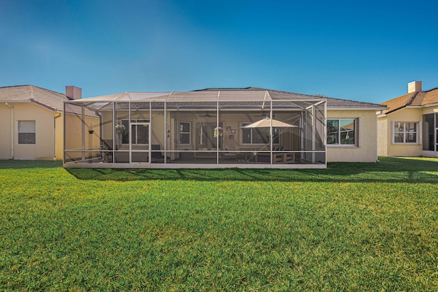 rear view of house featuring a lawn and a lanai