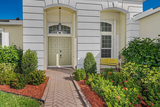 entrance foyer with light tile patterned floors, an inviting chandelier, and ornamental molding