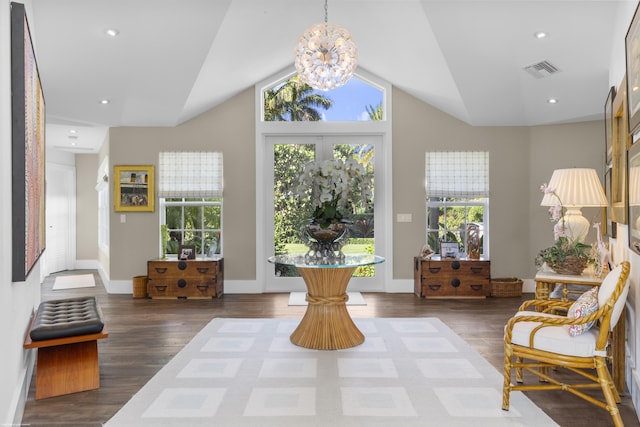 interior space with dark wood-type flooring, vaulted ceiling, and a notable chandelier