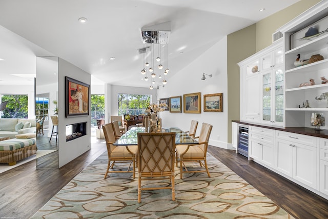 dining space with dark hardwood / wood-style floors, beverage cooler, and vaulted ceiling