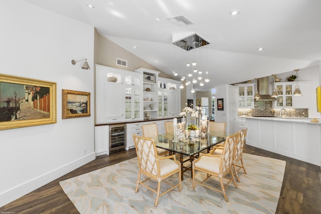 dining room featuring vaulted ceiling, dark hardwood / wood-style floors, wine cooler, and sink