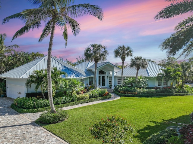 view of front facade featuring a lawn and a garage