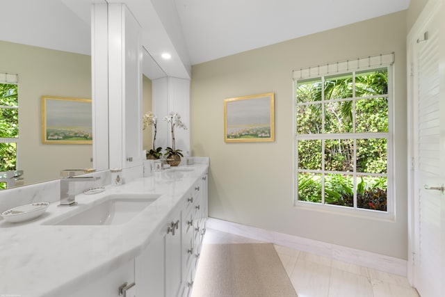 bathroom featuring tile patterned flooring, vanity, and vaulted ceiling