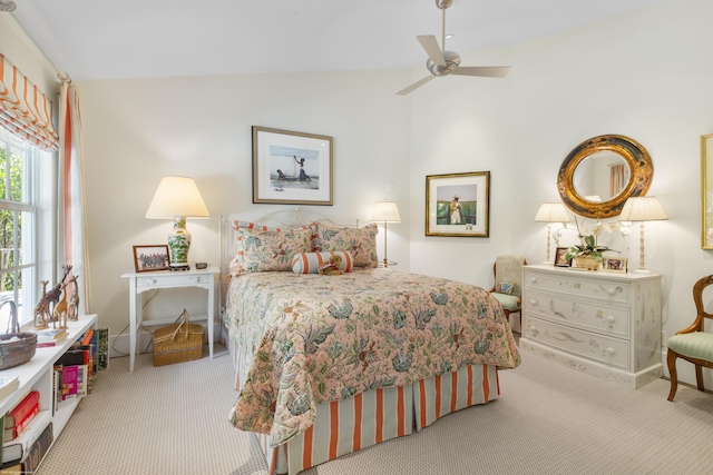 bedroom featuring ceiling fan, light colored carpet, and vaulted ceiling