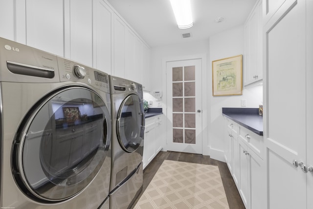 washroom featuring cabinets, separate washer and dryer, and dark wood-type flooring