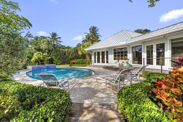 view of swimming pool with a patio and french doors