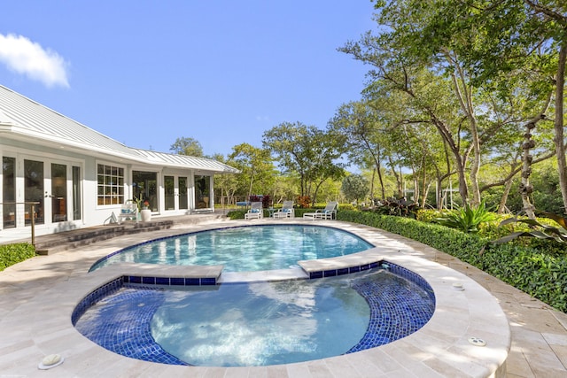 view of pool with an in ground hot tub, french doors, and a patio