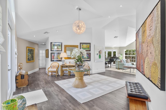 foyer featuring hardwood / wood-style flooring, high vaulted ceiling, and an inviting chandelier