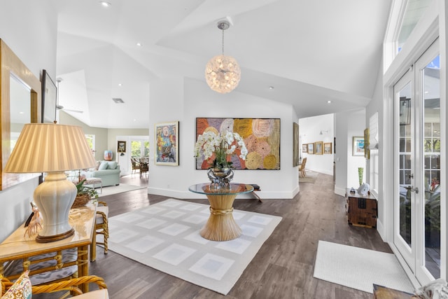 interior space featuring a chandelier, french doors, dark hardwood / wood-style flooring, and high vaulted ceiling