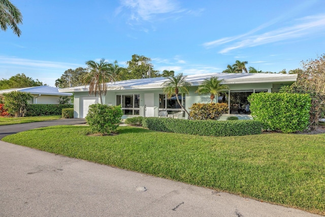 ranch-style house with a garage and a front lawn