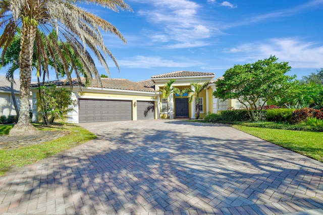 mediterranean / spanish-style house featuring a front yard and a garage