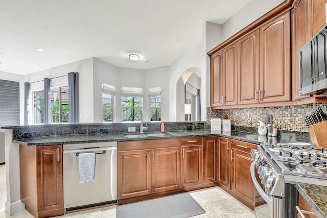 kitchen featuring sink, dark stone counters, and appliances with stainless steel finishes