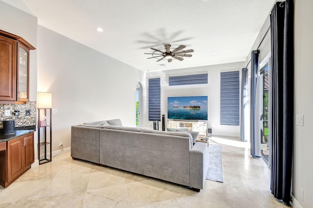 living room with a textured ceiling and ceiling fan