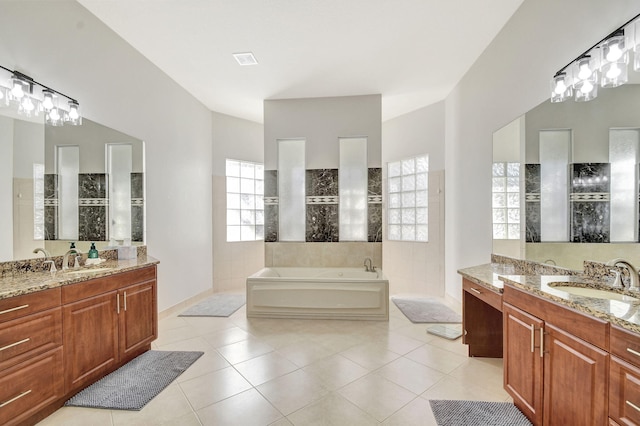 bathroom with tile patterned flooring, vanity, and a washtub