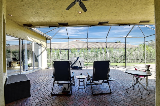 view of patio / terrace with area for grilling, ceiling fan, and a lanai