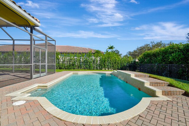 view of pool with a lanai, pool water feature, and a patio