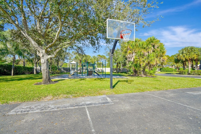 view of basketball court featuring a playground and a yard