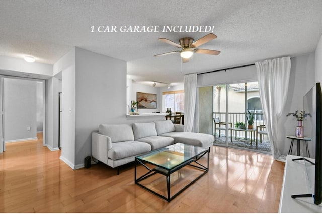 living room with a textured ceiling, light hardwood / wood-style floors, and ceiling fan