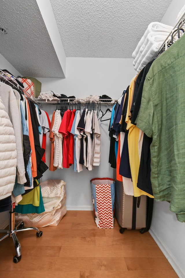 bedroom featuring a closet, a ceiling fan, connected bathroom, a textured ceiling, and wood finished floors