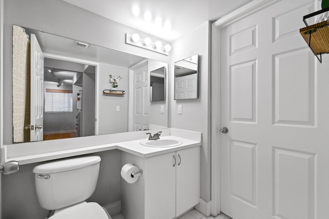 bathroom with toilet, vanity, wood finished floors, and visible vents