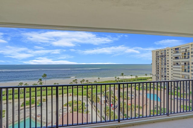 balcony with a water view and a view of the beach