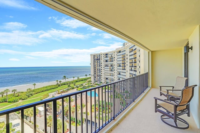 balcony featuring a water view and a view of the beach