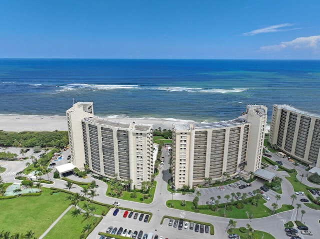 birds eye view of property with a water view and a beach view