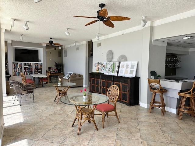 dining room with ceiling fan, crown molding, and a textured ceiling