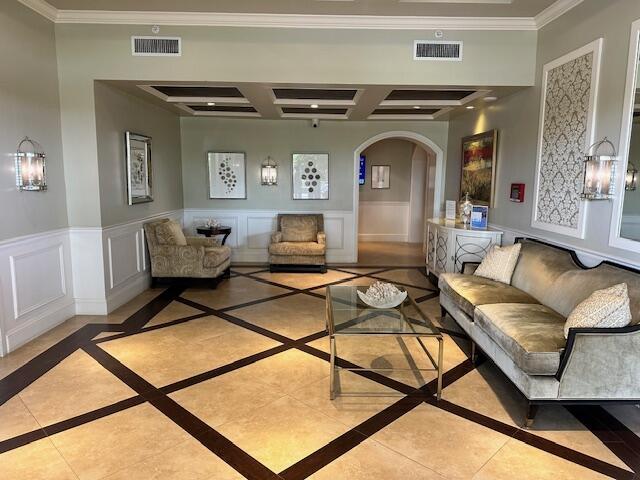 living room with ornamental molding and light tile patterned floors