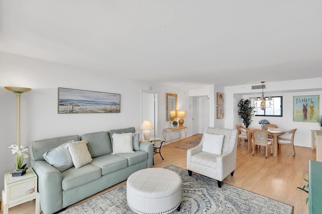 living room with a chandelier and light hardwood / wood-style floors