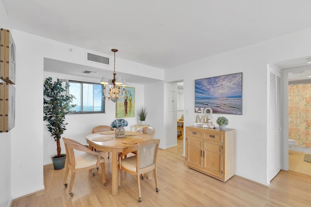 dining area featuring light hardwood / wood-style flooring and a chandelier