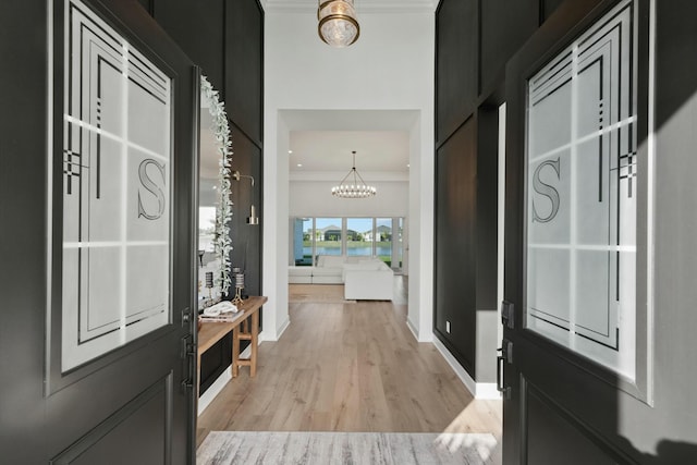 interior space with a chandelier, crown molding, and light hardwood / wood-style floors