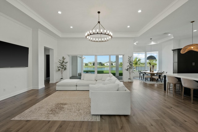 living room with crown molding, dark hardwood / wood-style floors, and an inviting chandelier