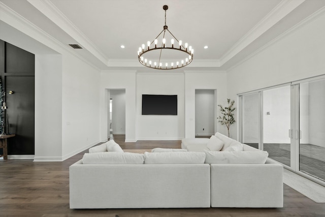 living room with a raised ceiling, ornamental molding, dark hardwood / wood-style floors, and a notable chandelier