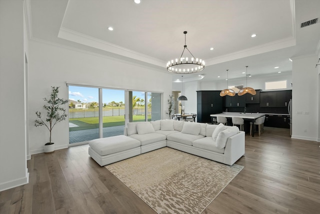 living room featuring dark hardwood / wood-style floors, a high ceiling, and an inviting chandelier