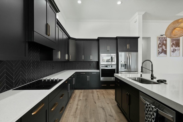 kitchen featuring crown molding, sink, light wood-type flooring, tasteful backsplash, and stainless steel appliances