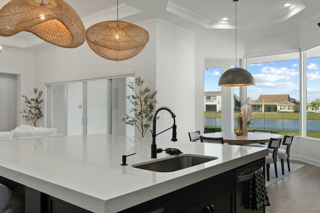 kitchen featuring a healthy amount of sunlight, sink, hanging light fixtures, and ornamental molding